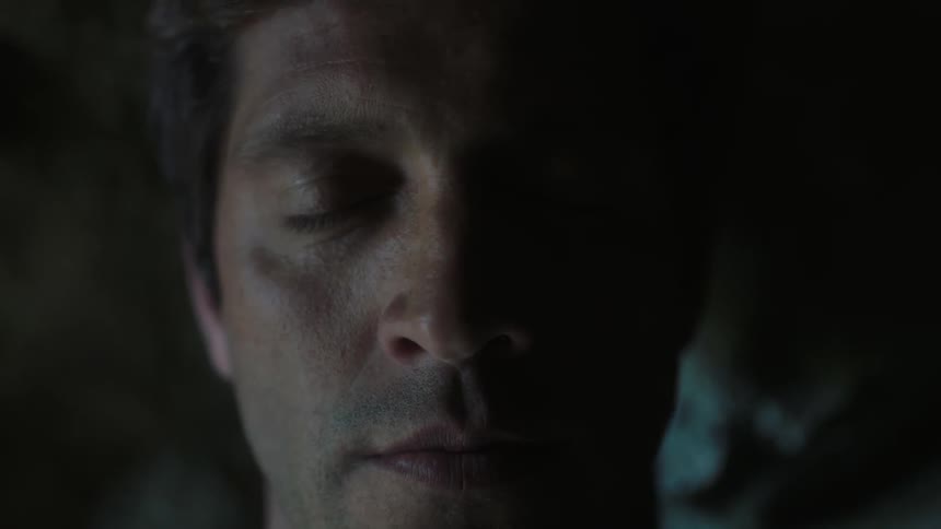 Close-up of a man opening his eyes in a dark area