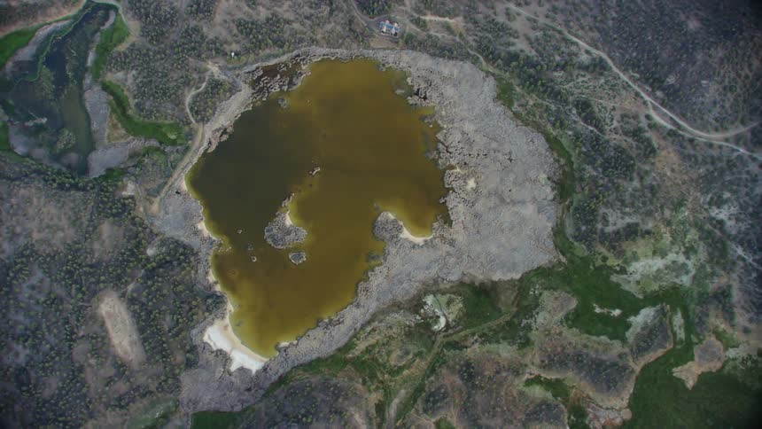Top down aerial view of the yellow water on an isolated lake at daytime
