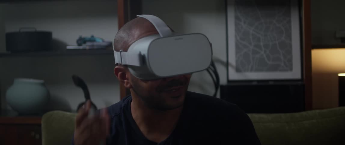 A man smiling and talking while wearing a virtual reality headset