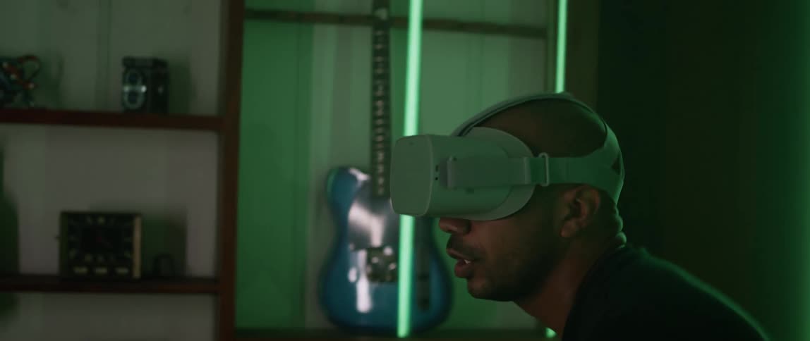 A man at home swings his arms as he plays a virtual reality game