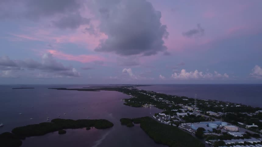 An aerial view of a factory on the shore at dusk