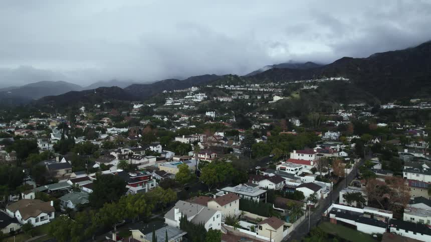 Aerial view of residential area next to mountain on a cloudy day in the city