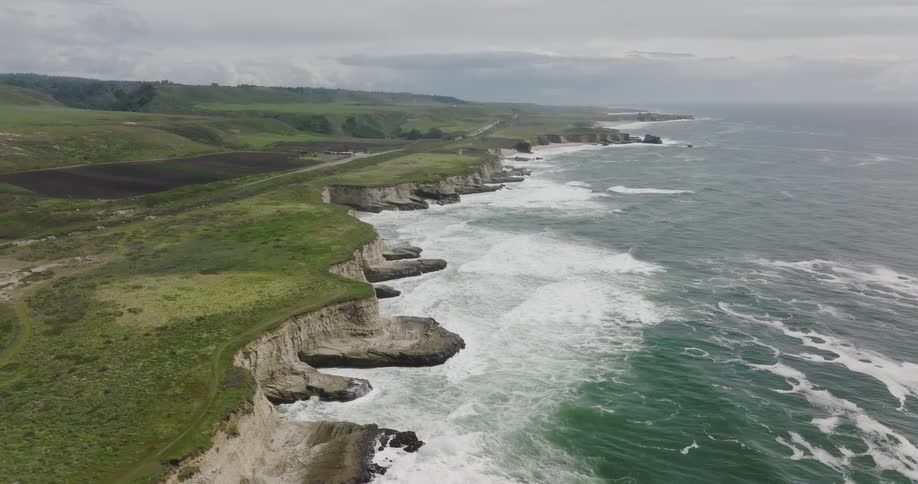 Aerial view of the cliffs on the coast next to the ocean at daytime
