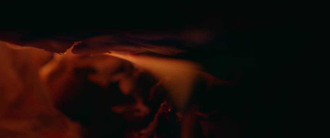 Close up of orange flames consuming the underside of a log