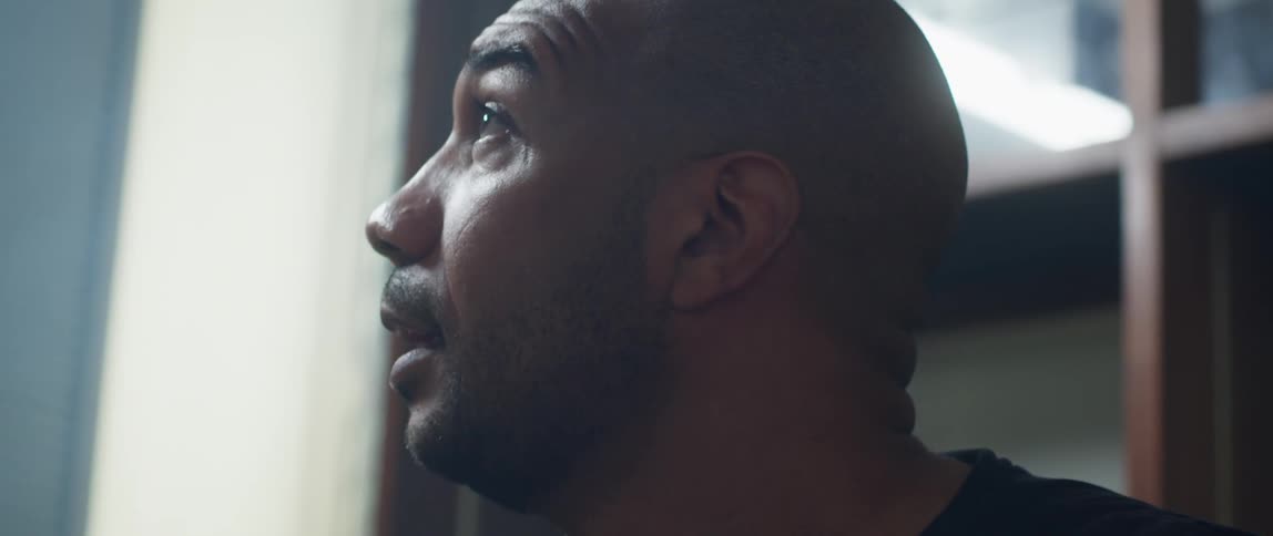 A man removes a virtual reality headset from his face and gazes around at his surroundings