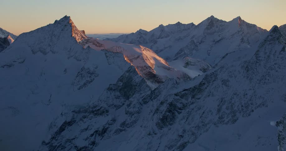 Aerial view of snowy mountain range at dusk