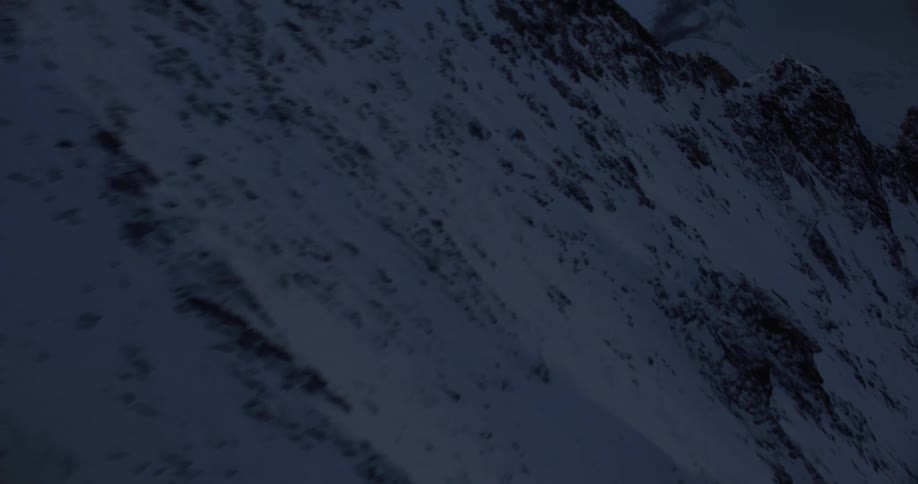 Aerial view of snowy mountain ridge at dusk