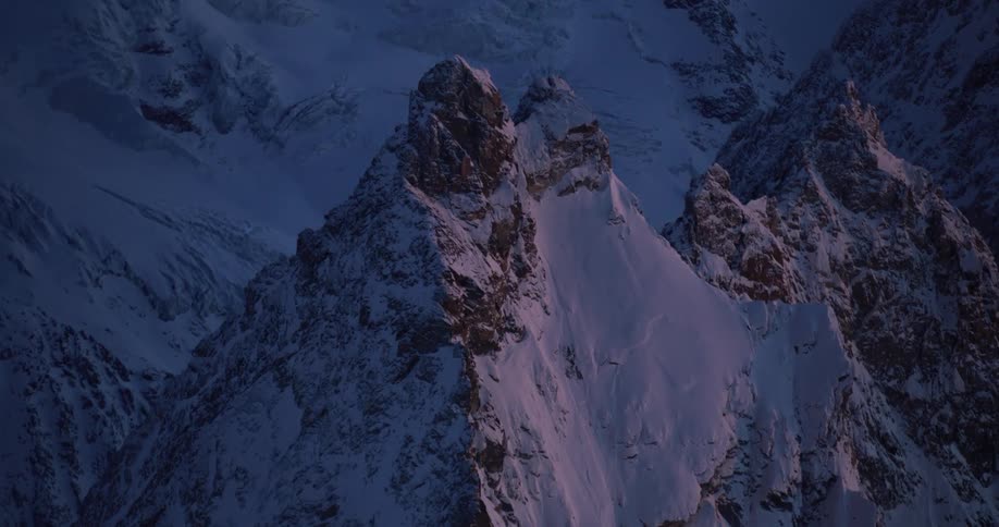 An aerial view of a snowy mountain range in the wilderness