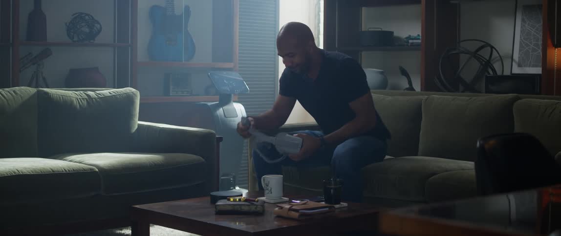 A man is sitting in his living room and playing video games