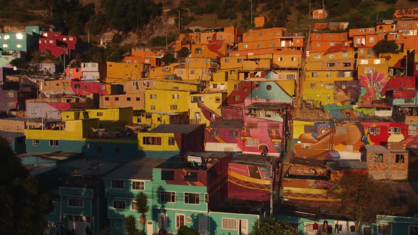 People walk through a neighborhood filled with colorful homes