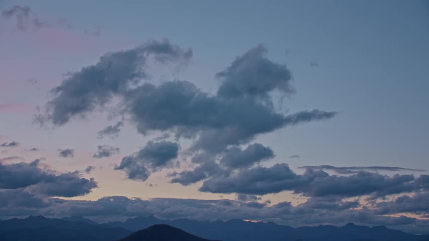 Puffy clouds roll inover a mountain range