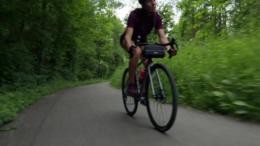 Male cyclist with helmet jersey shirt and shorts rides bicycle on cycle path in the forest