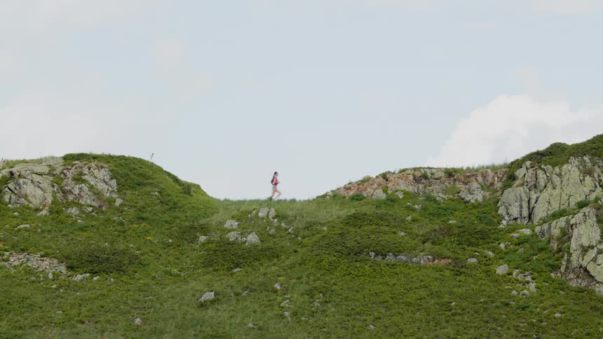 Young woman jogging over the hills at daytime