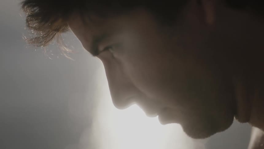 Close-up of a man with his head bent forward and slowly looking forward