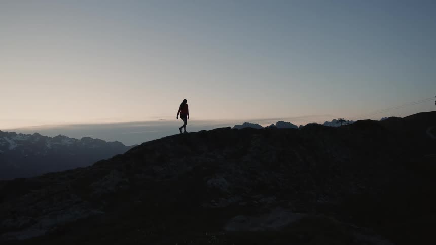A woman hikes up the side of a mountain