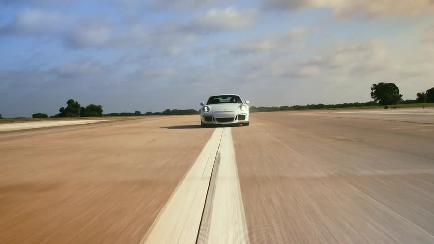 White sports car driving down road