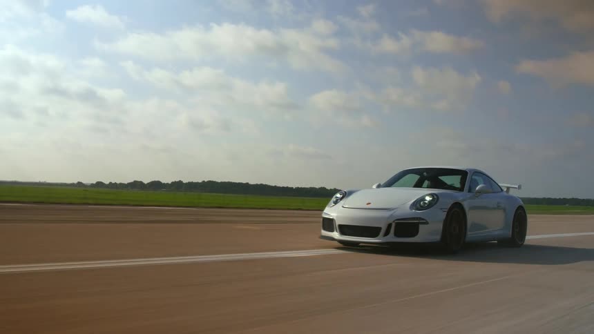 A vehicle is driving down a grasslined road