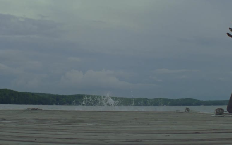 A man and woman sprint along a dock before jumping into the water together