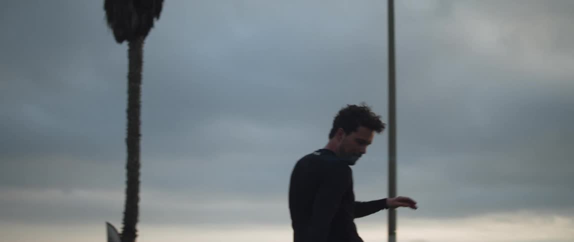 A man kicks a soccer ball around on the beach