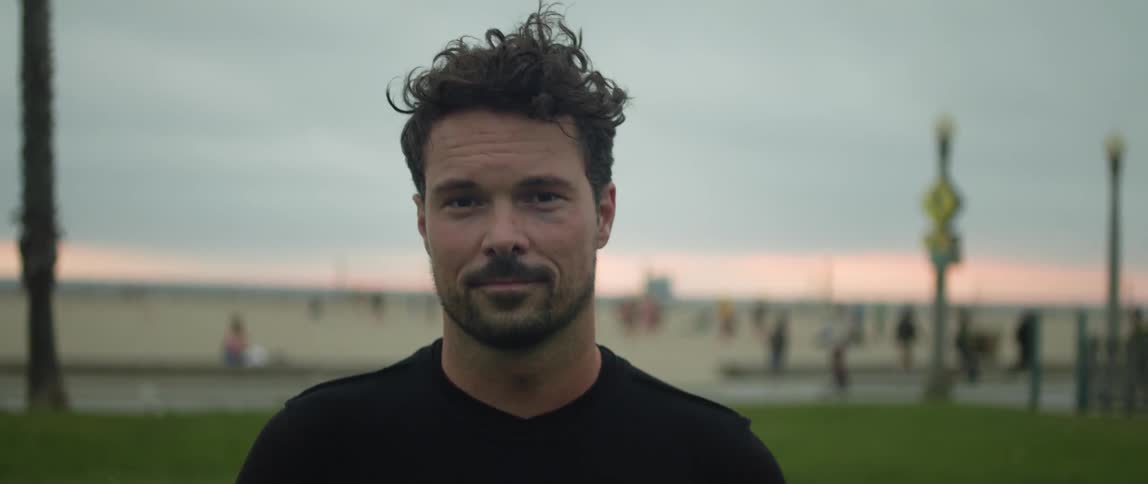 A male soccer player posing for a portrait outside at sunset