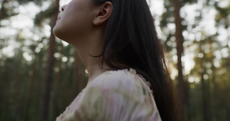 Female standing in the woods meditating