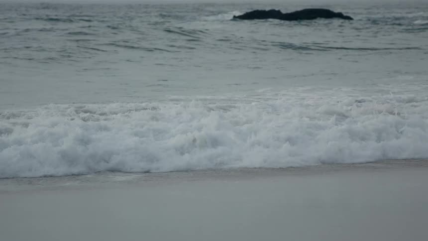 A wave crashes on to the beach