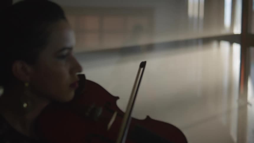 Three students play musical instruments in a classroom