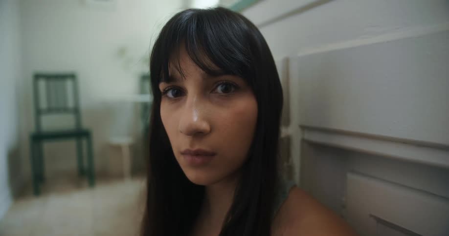 Close up of the face of a young woman with long black hair looking at the camera