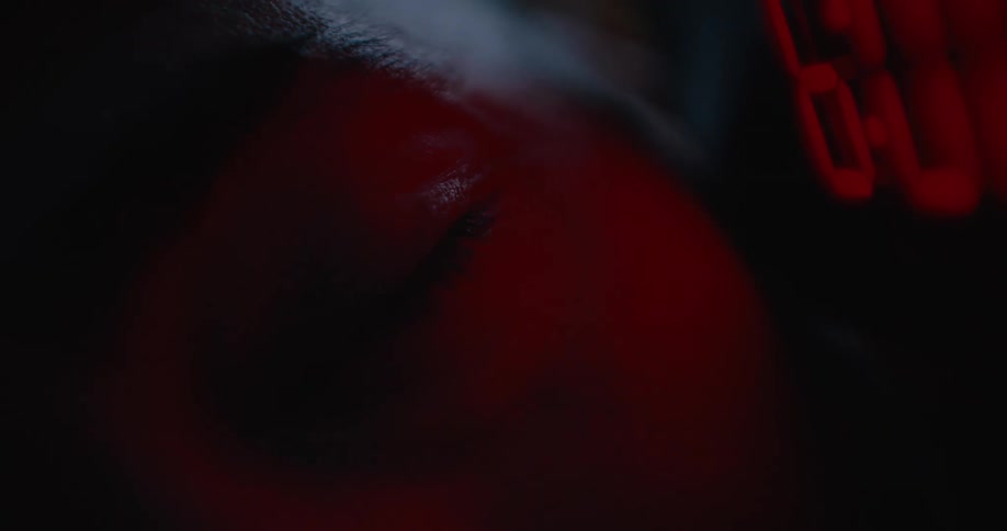 Close up of womans teary eye next to digital clock at night