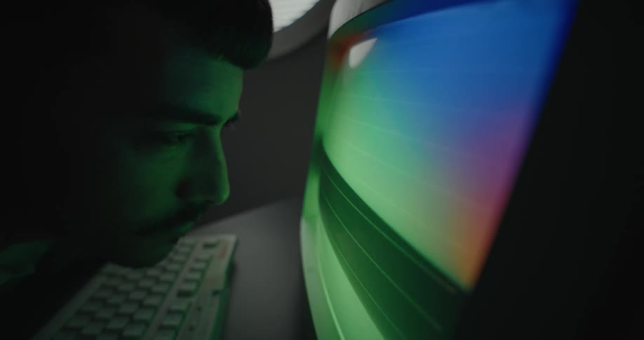 A man is looking closely at the monitor