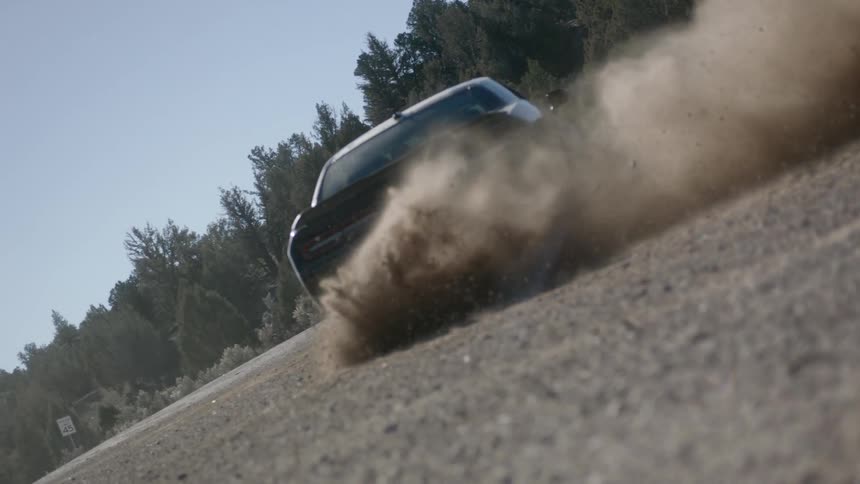 Sports car spinning up dust purposely in slow motion