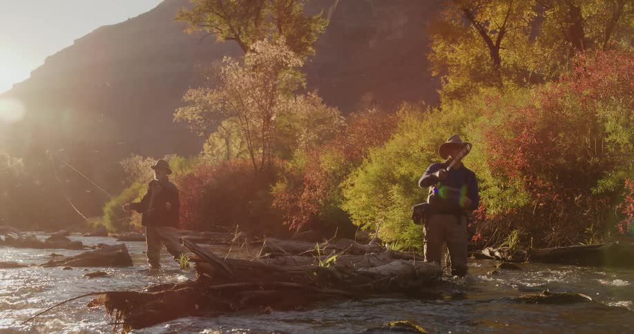 Leaves are changing color as men fish in a river