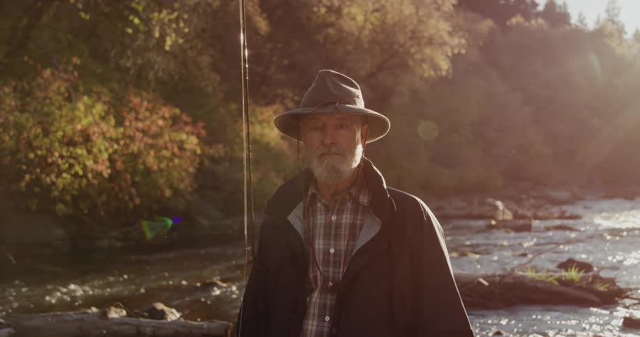 A man is outdoors on a river and is fishing