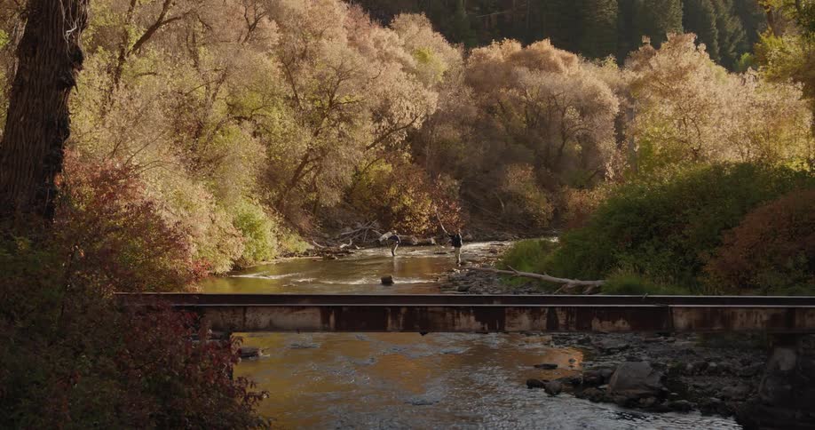 Two people are fishing on a river together