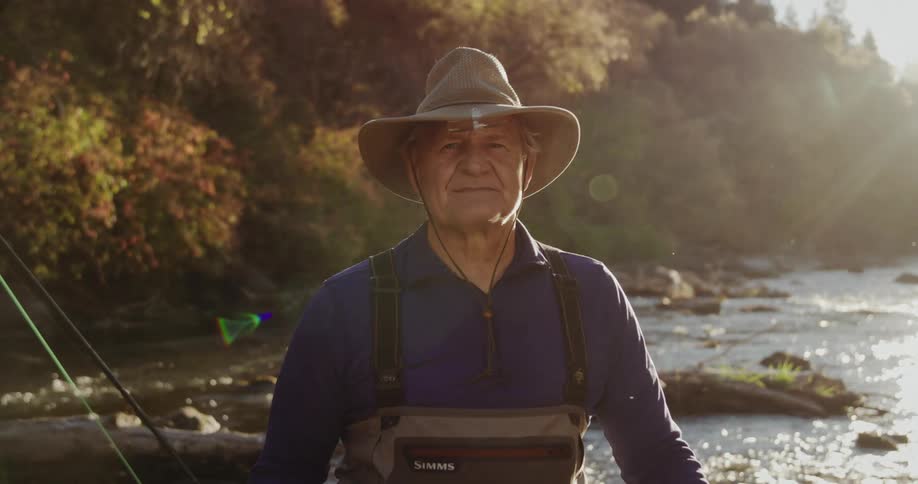 A man is on a river during the fall season