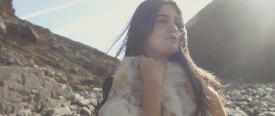 Wind blows on a woman standing in the sun