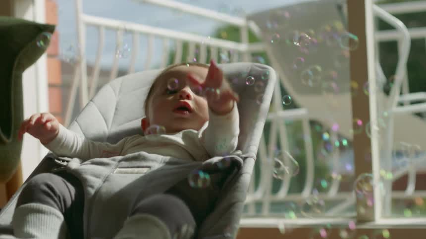A baby sitting around with bubbles