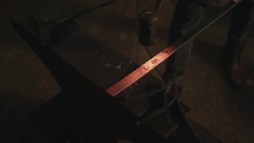 A person is hammering something in a dark room