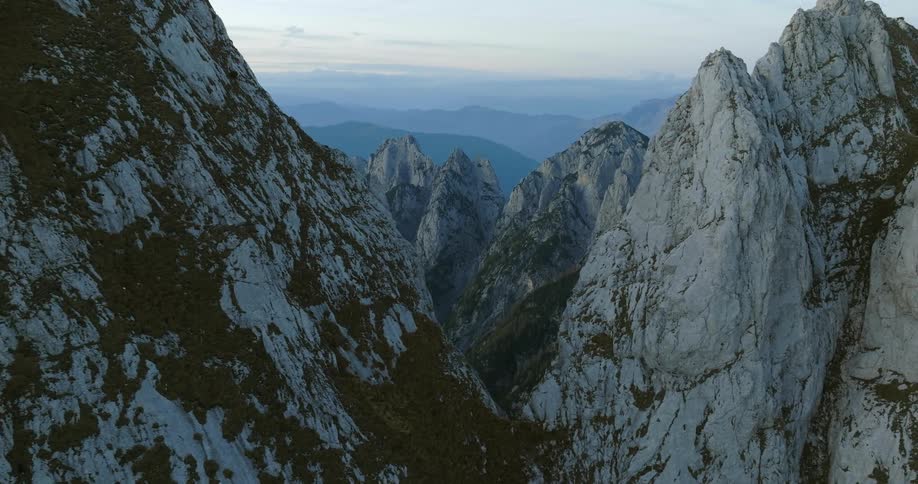 Sharp tall peaks covered in ice and snow rise up in a mountain range