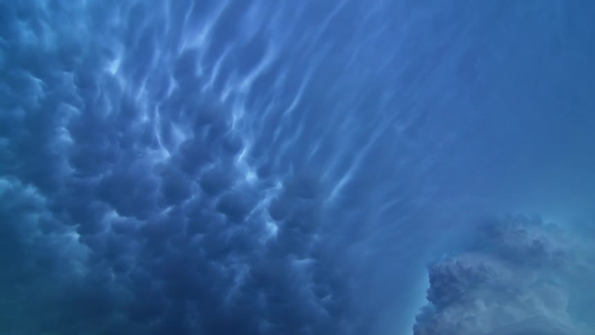 A thick layer of beautiful blueish clouds slowly pass overhead