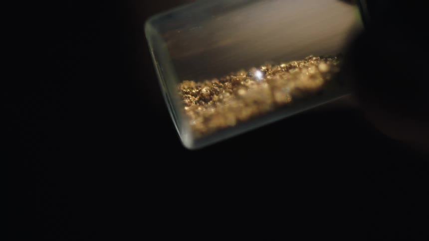 A person holding gold in a jar