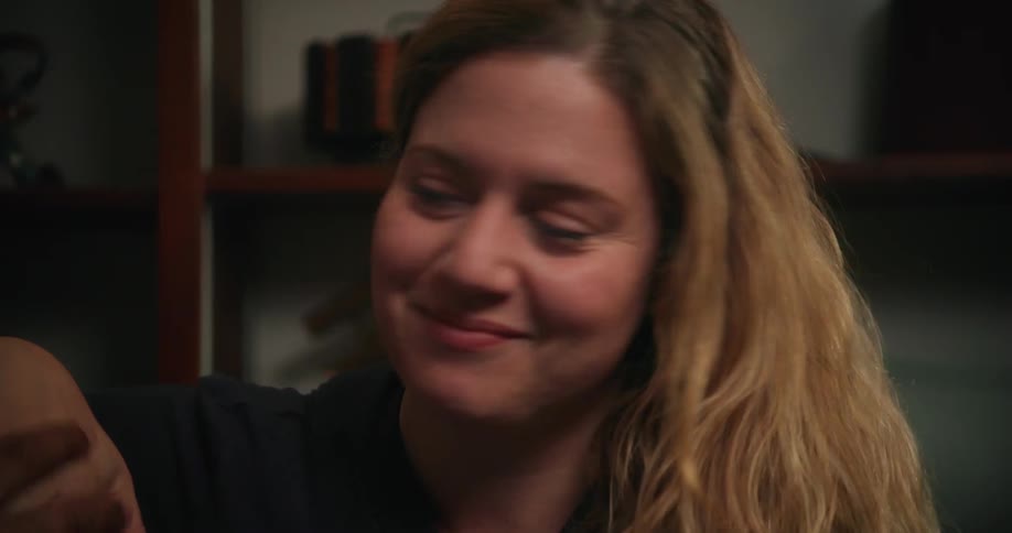 A couple sitting in a room smiling and talking lovingly