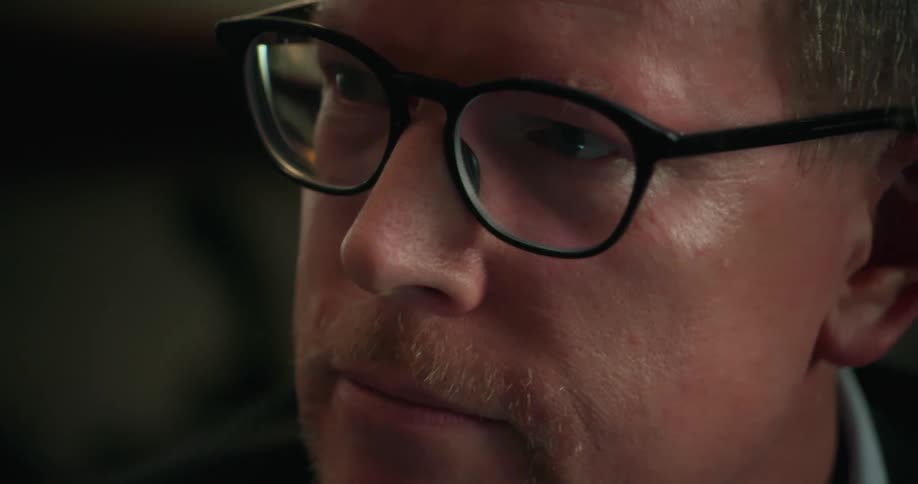 Closeup of mans face wearing glasses nodding