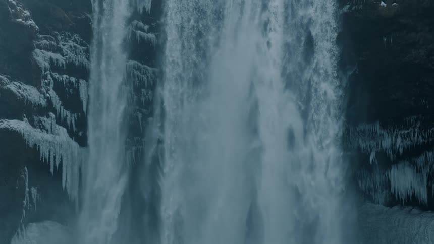 A waterfall is displayed outdoors during the winter