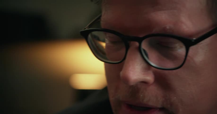 A man with black glasses are talking