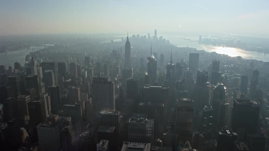 A breathtaking 4K aerial flyover approach to the iconic Empire State Building in Midtown Manhattan amidst a hazy winter morning showcasing the citys superstructures