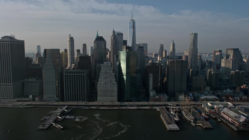 Winter aerial footage of Lower Manhattan skyscrapers and East River piers with the Freedom Tower visible in the distance