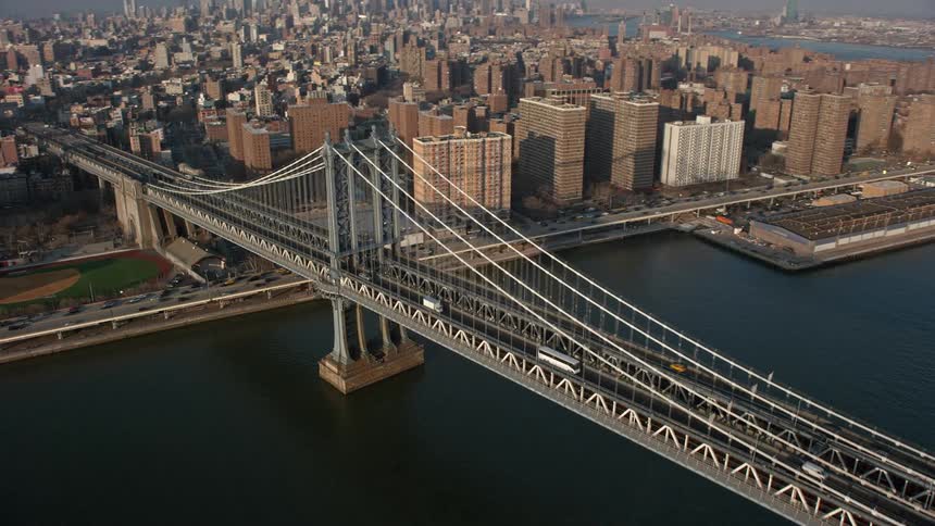 Light traffic crosses the iconic Manhattan Bridge against picturesque NY cityscape on a winter day
