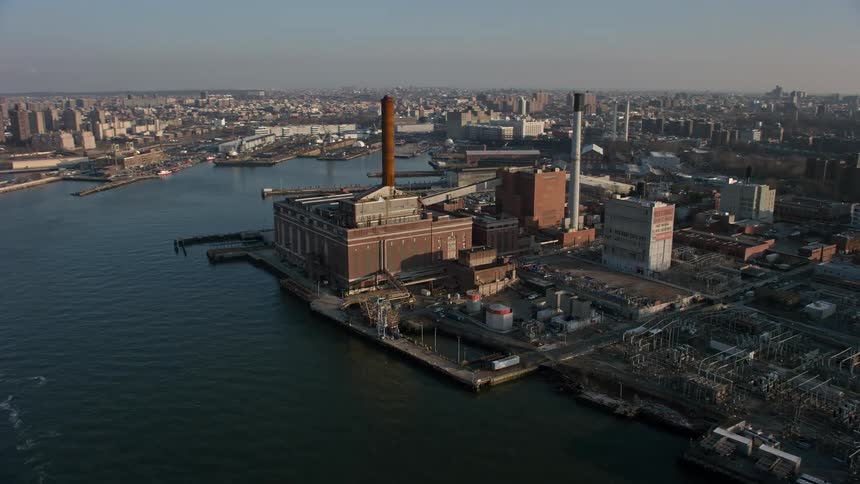 Aerial view of a riverfront power plant with smoke stacks in Brooklyn New York City during winter producing energy for the city