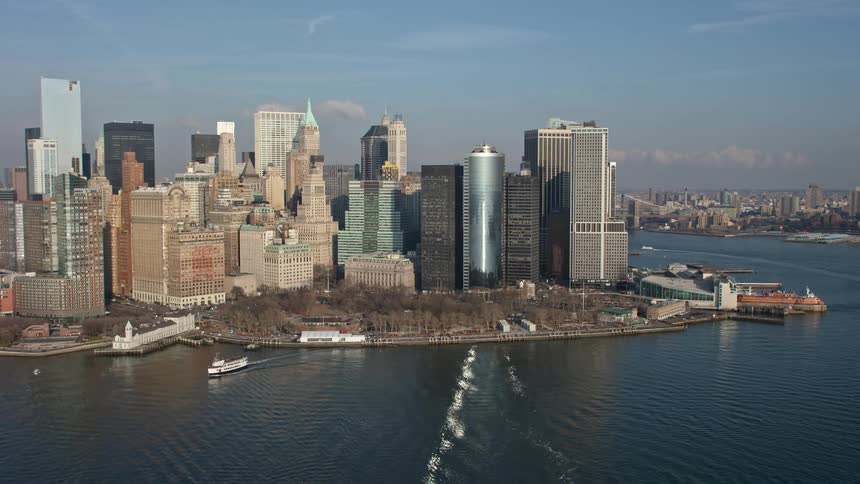 Aerial view of Battery Park and Lower Manhattan skyscrapers during winter with a clear blue sky